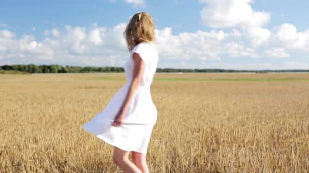 Усміхнена молода жінка в білій сукні на зерновому полі — стокове відео