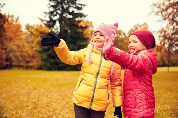 Deux petites filles heureuses agitant la main dans le parc d'automne — Photo