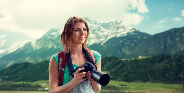 Mulher com mochila e câmera sobre montanhas — Fotografia de Stock