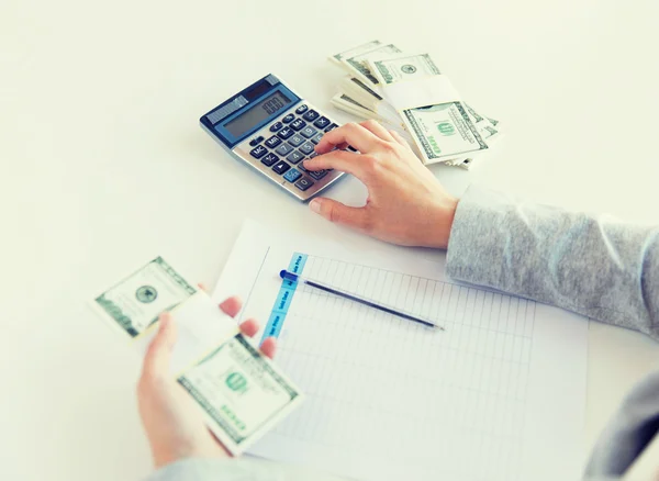 Close up of hands counting money with calculator — Stock Photo, Image