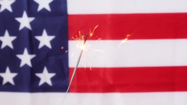 Close up van sparkler branden over Amerikaanse vlag — Stockvideo