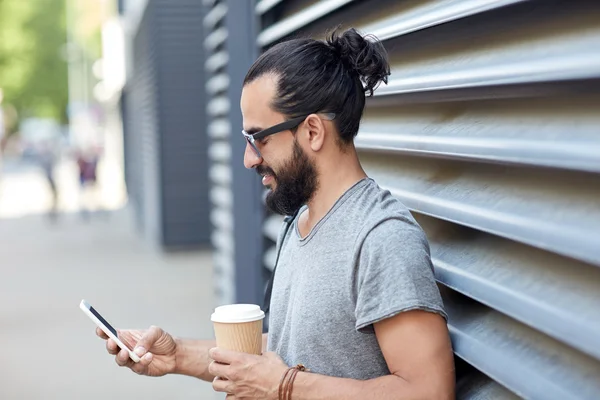 Człowiek z kawy SMS-y na smartfonie w mieście — Zdjęcie stockowe