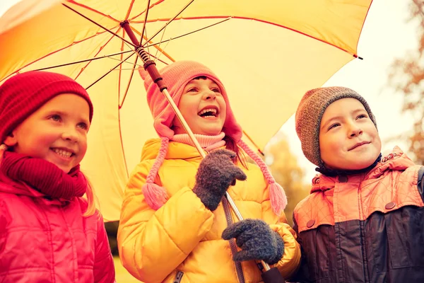 Niños felices con paraguas en el parque de otoño —  Fotos de Stock