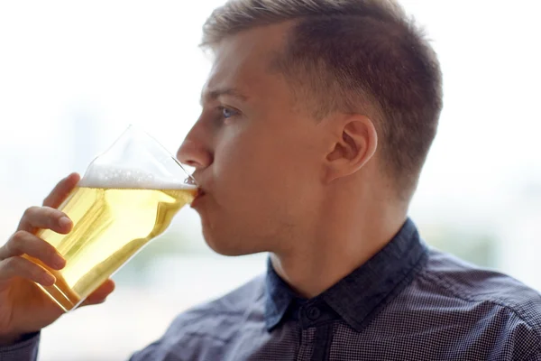 Close up of young man drinking beer from glass — Stock Photo, Image