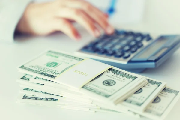 Close up of hand counting money with calculator — Stock Photo, Image