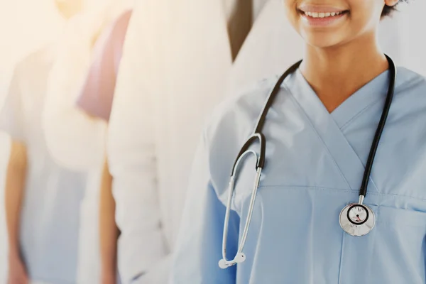 Närbild på glada läkare eller sjuksköterska med stetoskop — Stockfoto