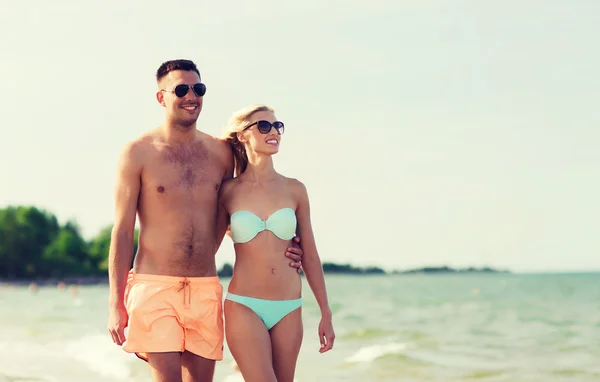 Couple heureux en maillot de bain marchant sur la plage d'été — Photo