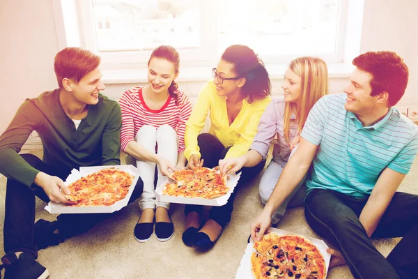 Cinque adolescenti sorridenti che mangiano pizza a casa — Foto Stock