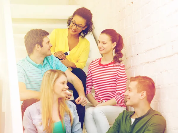 Lachende studenten met smartphone discussie — Stockfoto