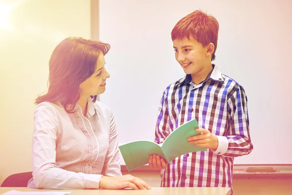 Schüler mit Notizbuch und Lehrer im Klassenzimmer — Stockfoto