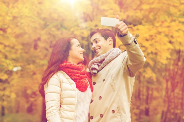 Smiling couple hugging in autumn park — Stock Photo, Image