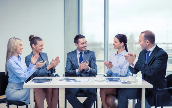 Business team with laptop clapping hands — Stock Photo, Image