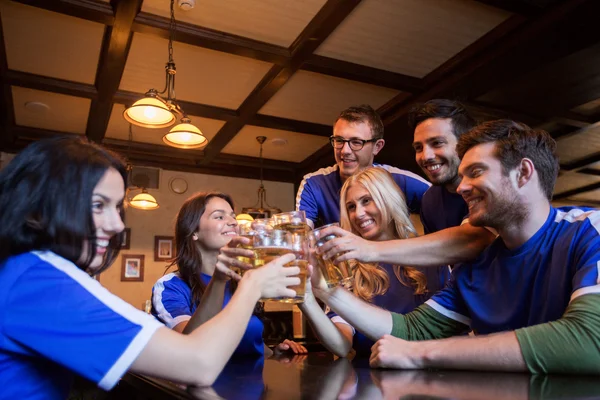 Tifosi di calcio clinking bicchieri di birra allo sport bar — Foto Stock