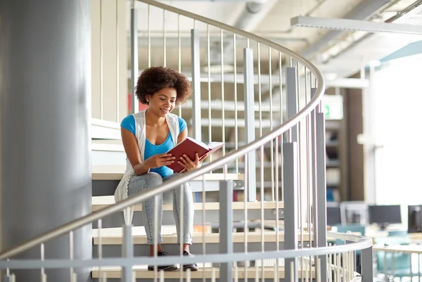 Africano studente ragazza lettura libro a biblioteca — Foto Stock