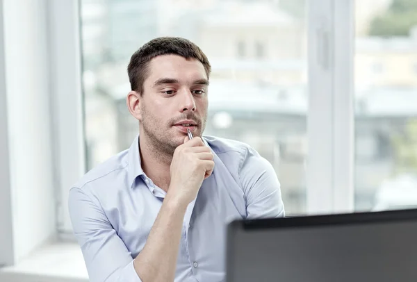 Joven hombre de negocios con ordenador portátil en la oficina — Foto de Stock