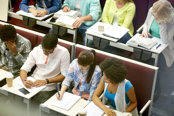 Group of students with notebooks at lecture hall — Stock Photo, Image