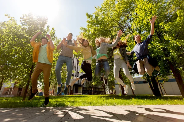 Felici studenti adolescenti o amici che saltano all'aperto — Foto Stock