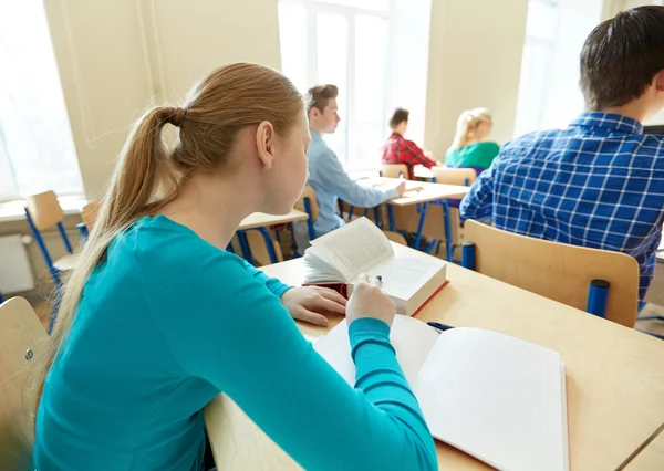 Grupp elever med böcker skriver skolan test — Stockfoto