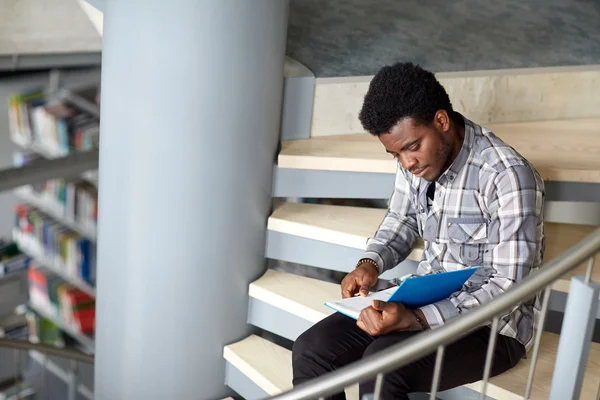 Afrikanska student pojke eller man läsa boken på biblioteket — Stockfoto