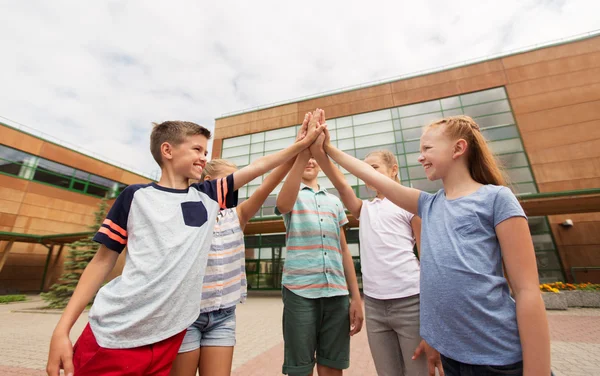 Grupo de niños haciendo high five en el patio de la escuela — Foto de Stock
