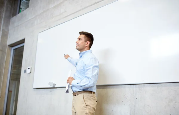 Teacher pointing marker to white board at lecture — Stock Photo, Image