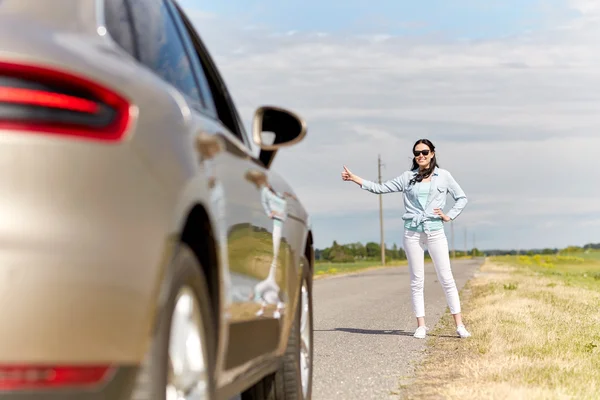 Mujer autostop y autostop en el campo — Foto de Stock