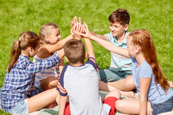 Grupo de crianças felizes fazendo alta cinco ao ar livre — Fotografia de Stock