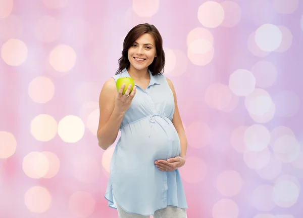 Happy pregnant woman holding green apple — Stock Photo, Image