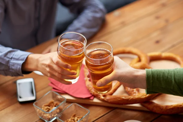 Close up of hands clinking beer at bar or pub — Stock Photo, Image