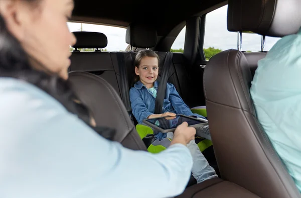 Happy family with tablet pc driving in car — Stock Photo, Image