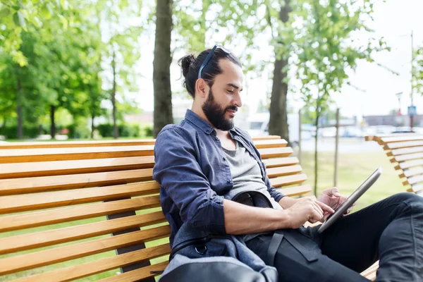 Hombre con la tableta de la PC sentado en la ciudad banco de la calle —  Fotos de Stock