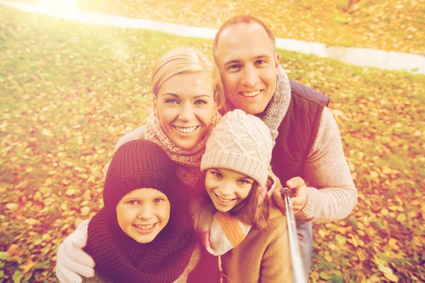 Lycklig familj med selfie pinne i höst park — Stockfoto