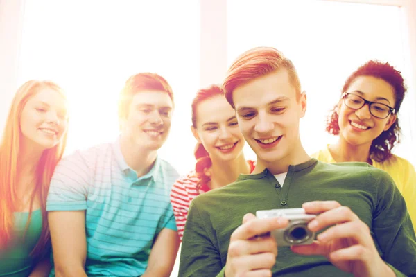 Studenti sorridenti con fotocamera digitale a scuola — Foto Stock