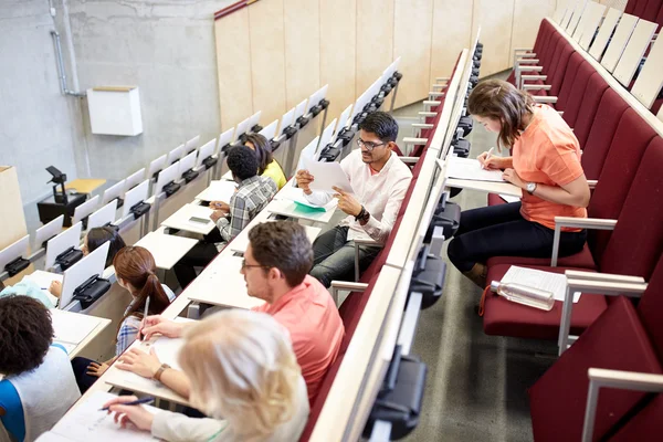 Группа студентов, пишущих тесты в лекционном зале — стоковое фото