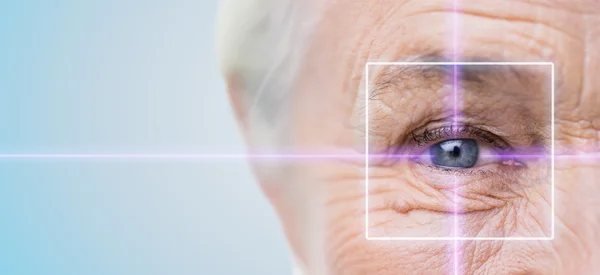 Primo piano della donna anziana occhio con luce laser — Foto Stock
