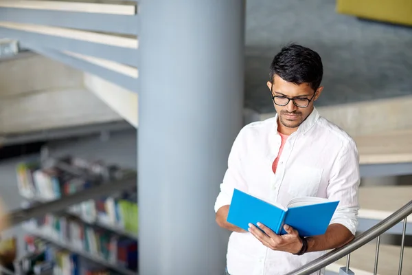 Hinduskie student mężczyzna lub chłopiec czytanie książki w bibliotece — Zdjęcie stockowe