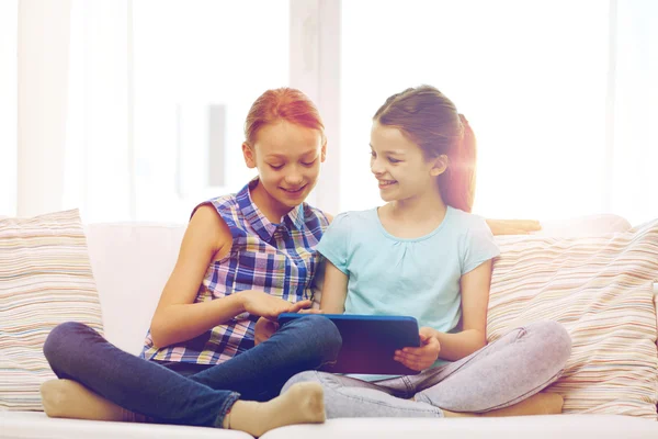 Chicas felices con la tableta PC sentado en el sofá en casa —  Fotos de Stock