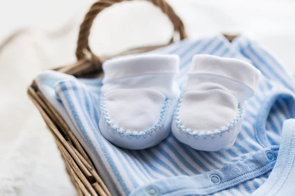 Закрытие детской одежды для новорожденного мальчика в корзине — стоковое фото