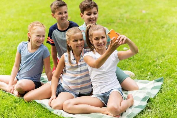 Crianças felizes ou amigos tomando selfie no parque de verão — Fotografia de Stock