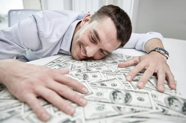 Hombre de negocios feliz con un montón de dinero en la oficina — Foto de Stock