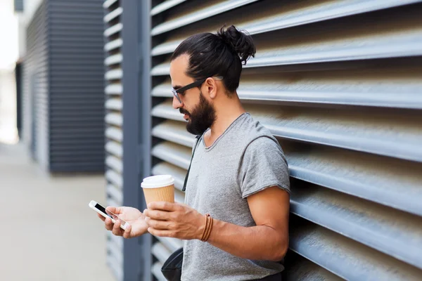 Hombre con mensajes de texto de café en el teléfono inteligente en la ciudad — Foto de Stock