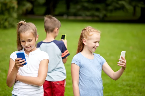 Τα παιδιά με smartphone που παίζει το παιχνίδι στο πάρκο καλοκαίρι — Φωτογραφία Αρχείου