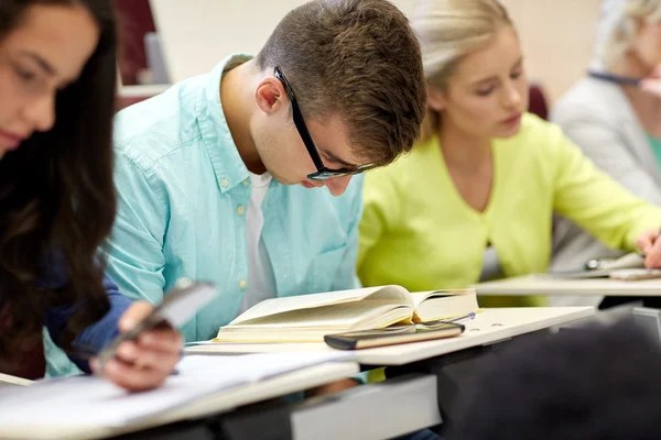 Maschio studente in occhiali lettura libro a lezione — Foto Stock