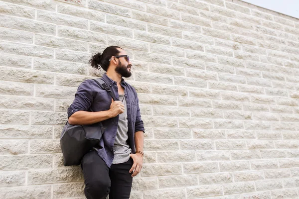Mann mit Rucksack steht an Stadtmauer — Stockfoto