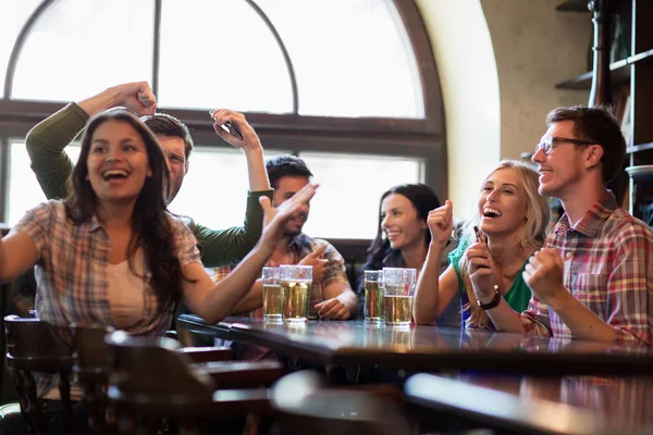 Friends with beer watching football at bar or pub — Stock Photo, Image