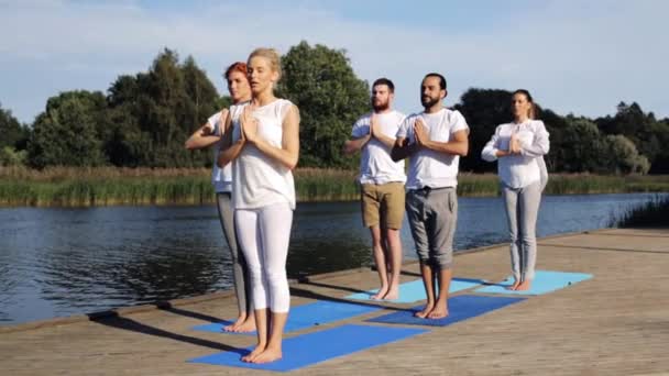 Groep mensen die buiten yoga oefeningen doen — Stockvideo