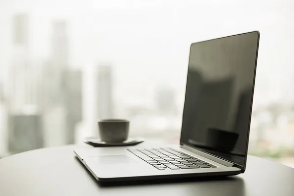 Primo piano del computer portatile e della tazza di caffè sul tavolo dell'ufficio — Foto Stock