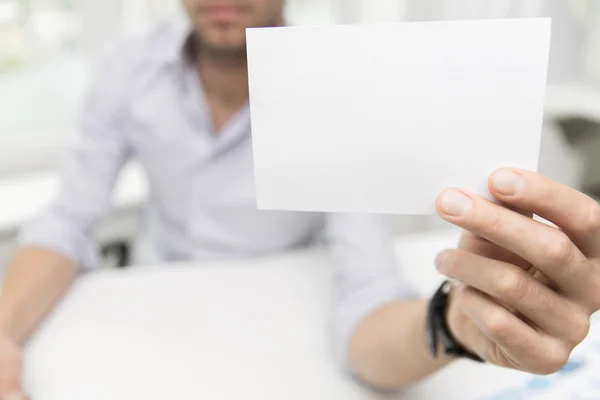 Primer plano del empresario con papel en blanco en la oficina — Foto de Stock