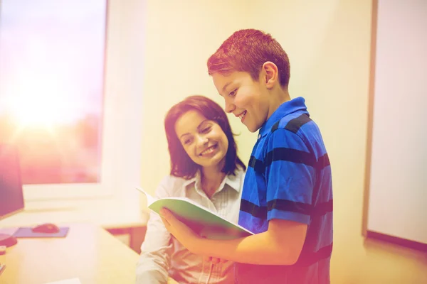 Colegial con cuaderno y profesor en aula — Foto de Stock