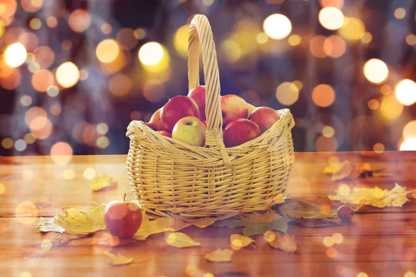 Närbild på korg med äpplen på träbord — Stockfoto